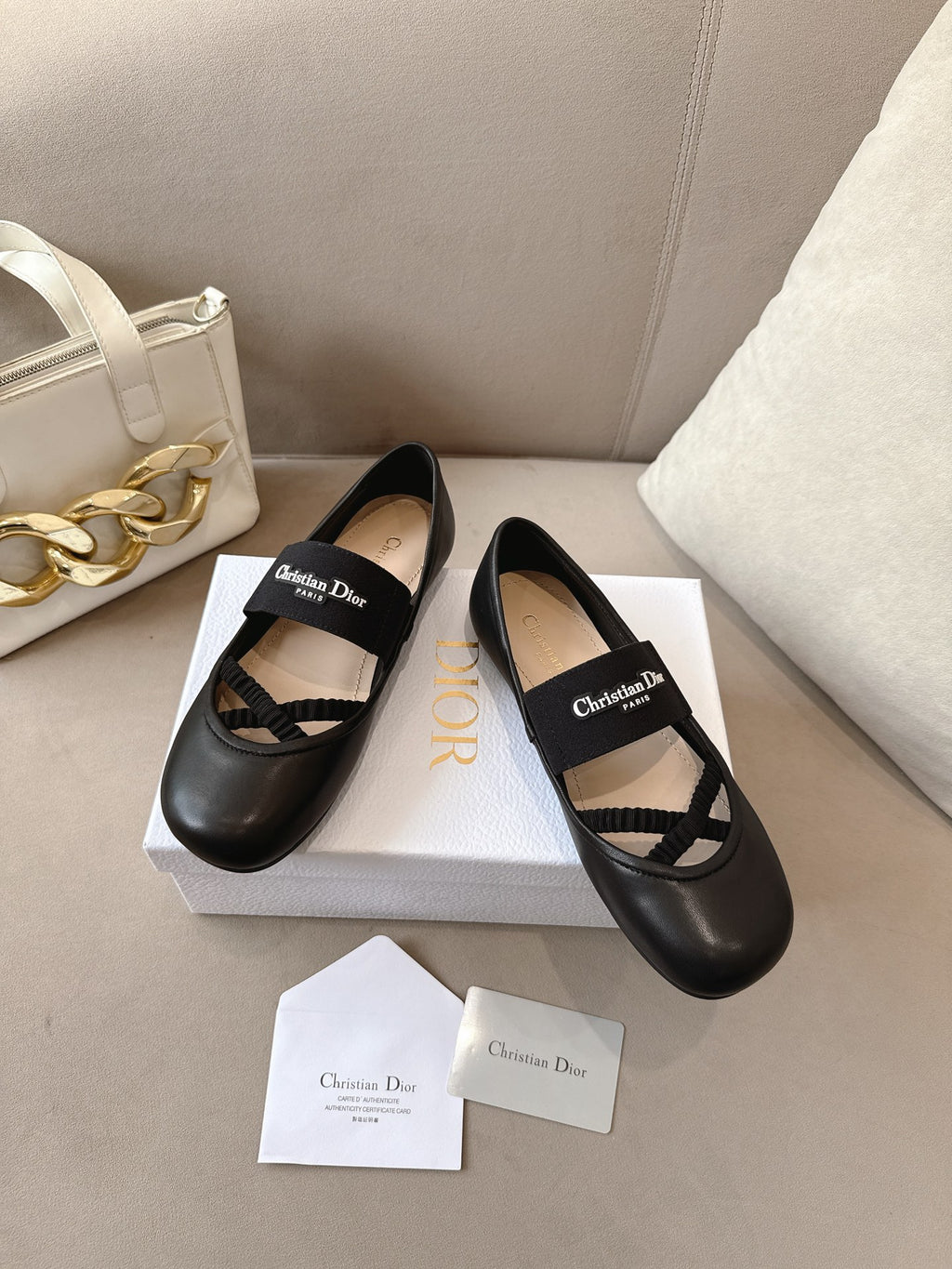 Pair of black women's ballet flats with crisscross strap and logo patch.