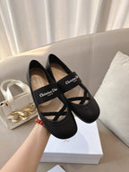 Black women's ballet flats with crisscross strap and logo patch, side view.