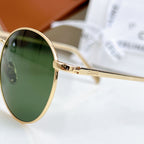 Gold sunglasses side arm with hinge detail and green tinted round lens