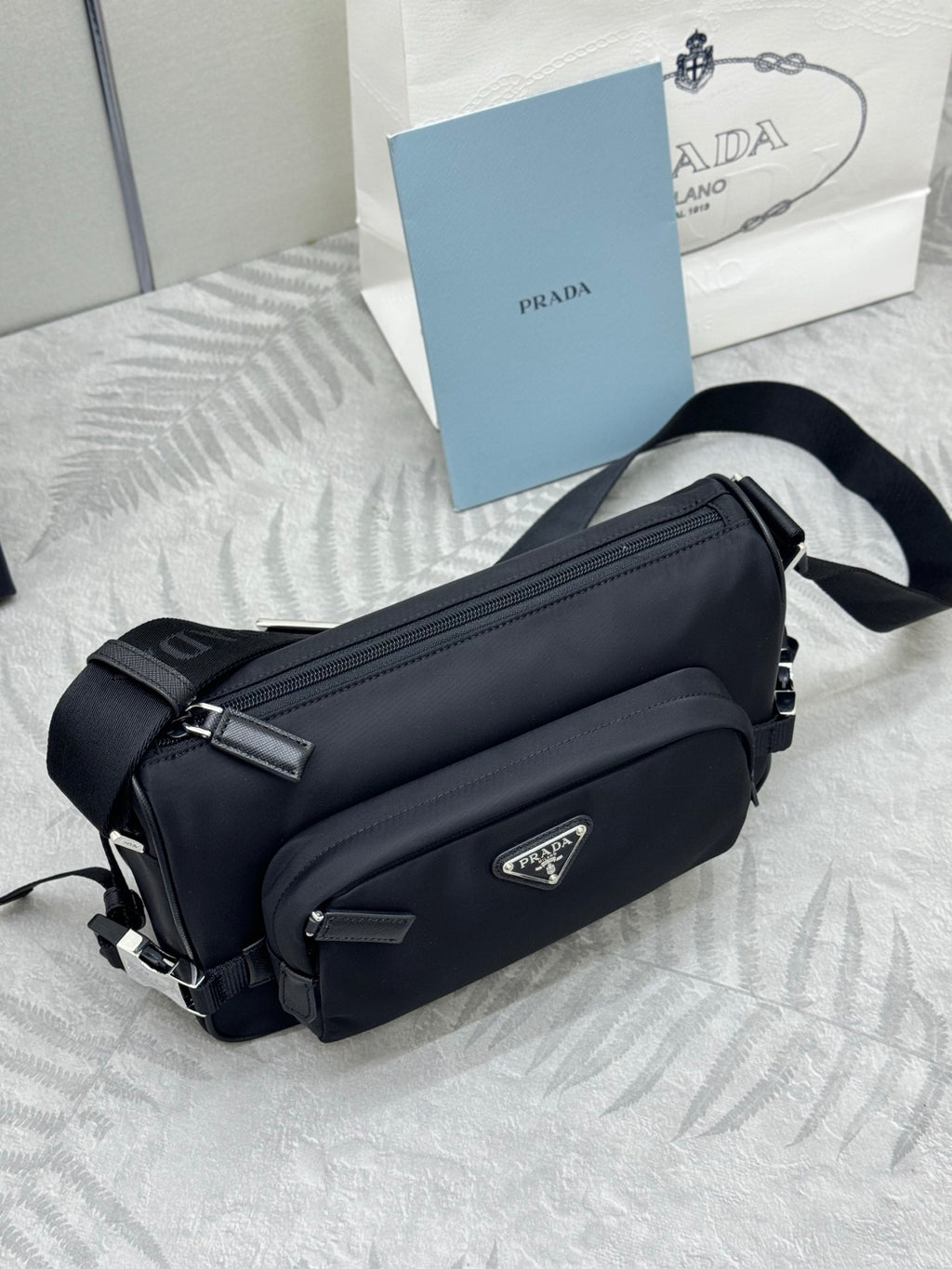 Prada crossbody bag, black finish with front flap and silver-tone buckle hardware