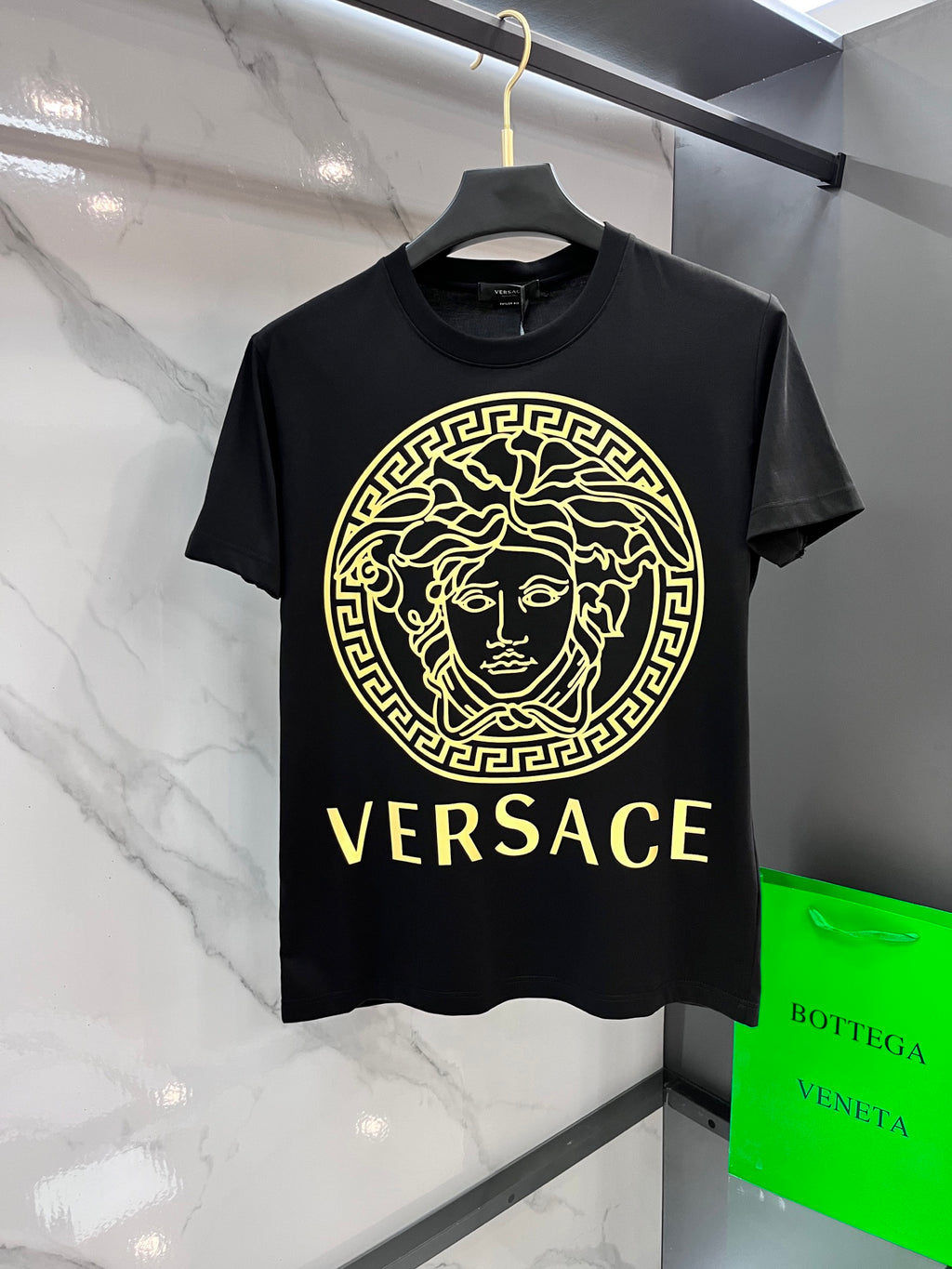 Black Versace graphic T-shirt with gold Medusa emblem and VERSACE text