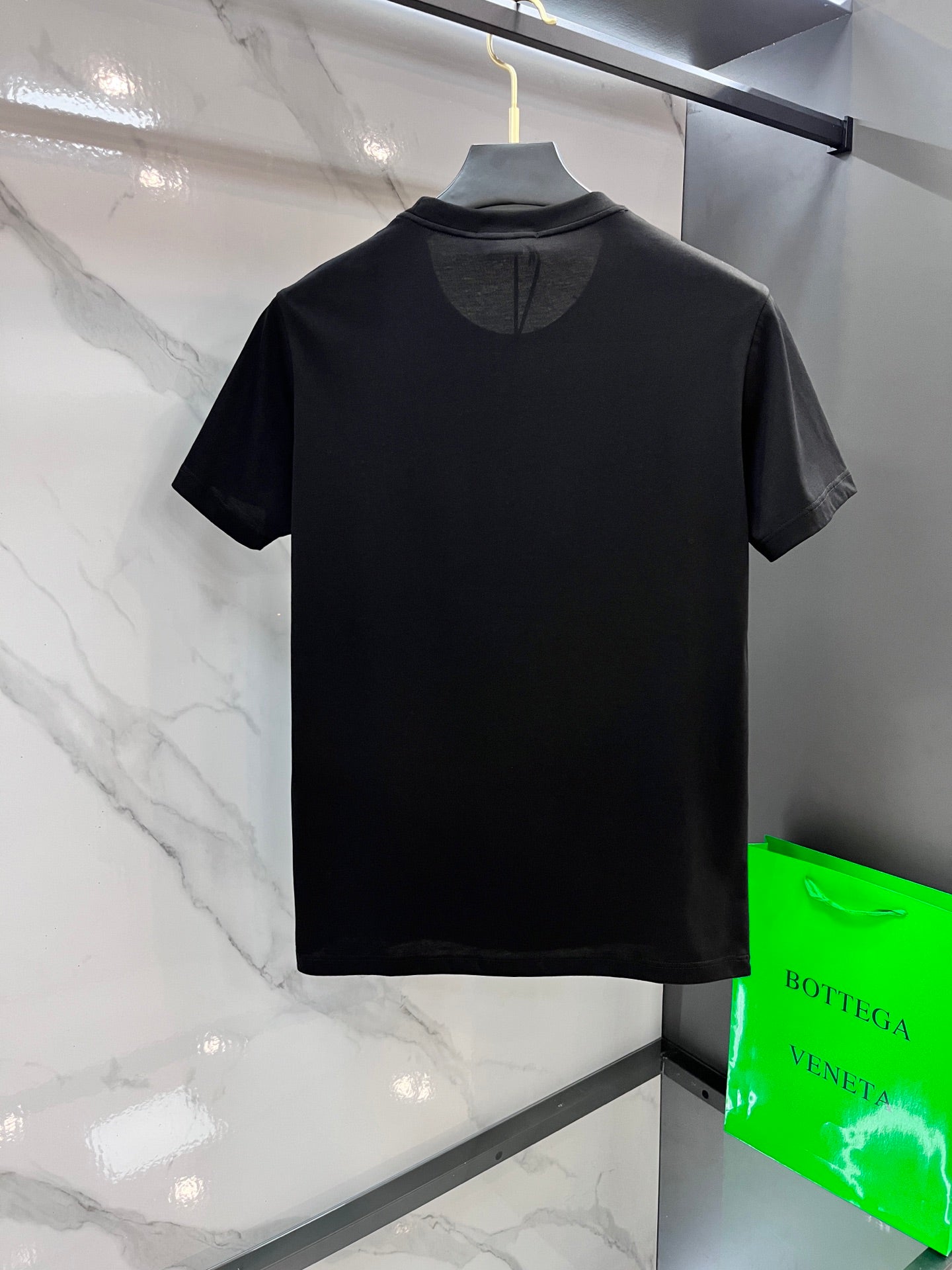 Black Versace logo T-shirt on hanger, back view