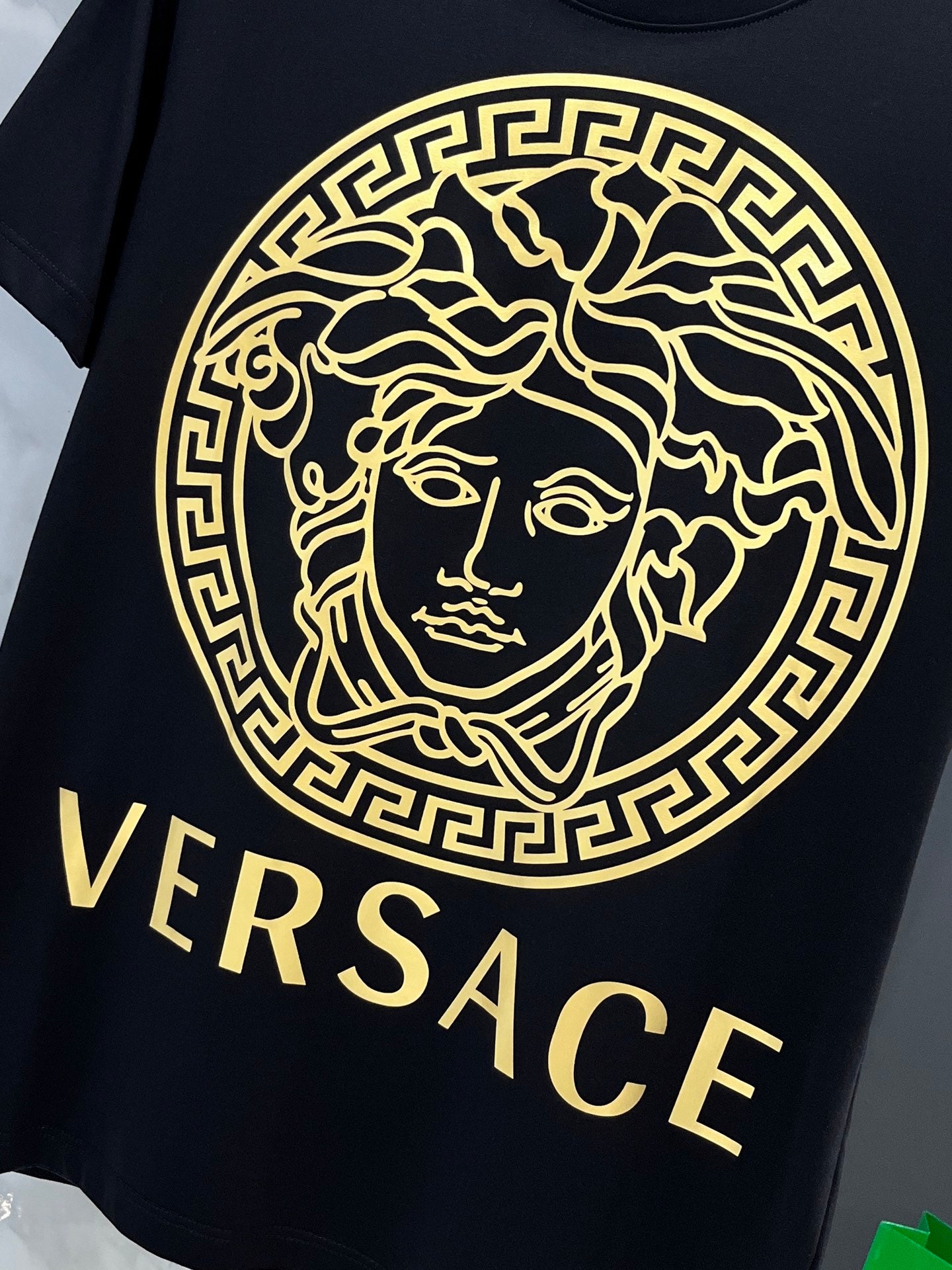 Black Versace T-shirt with large gold Medusa emblem and VERSACE text