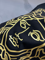 Close-up of gold Medusa graphic on black Versace T-shirt fabric