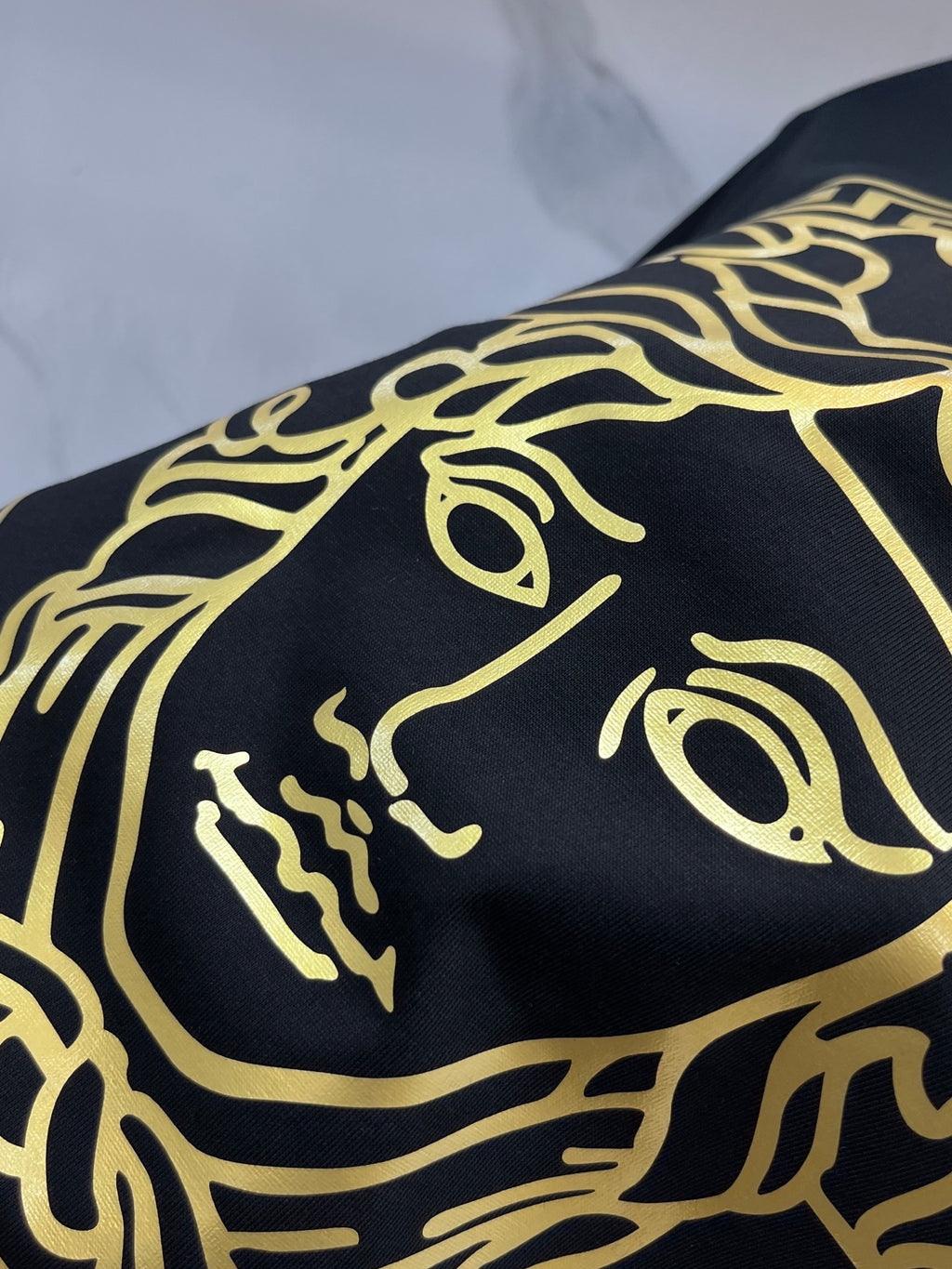 Versace gold Medusa face print on black T-shirt fabric