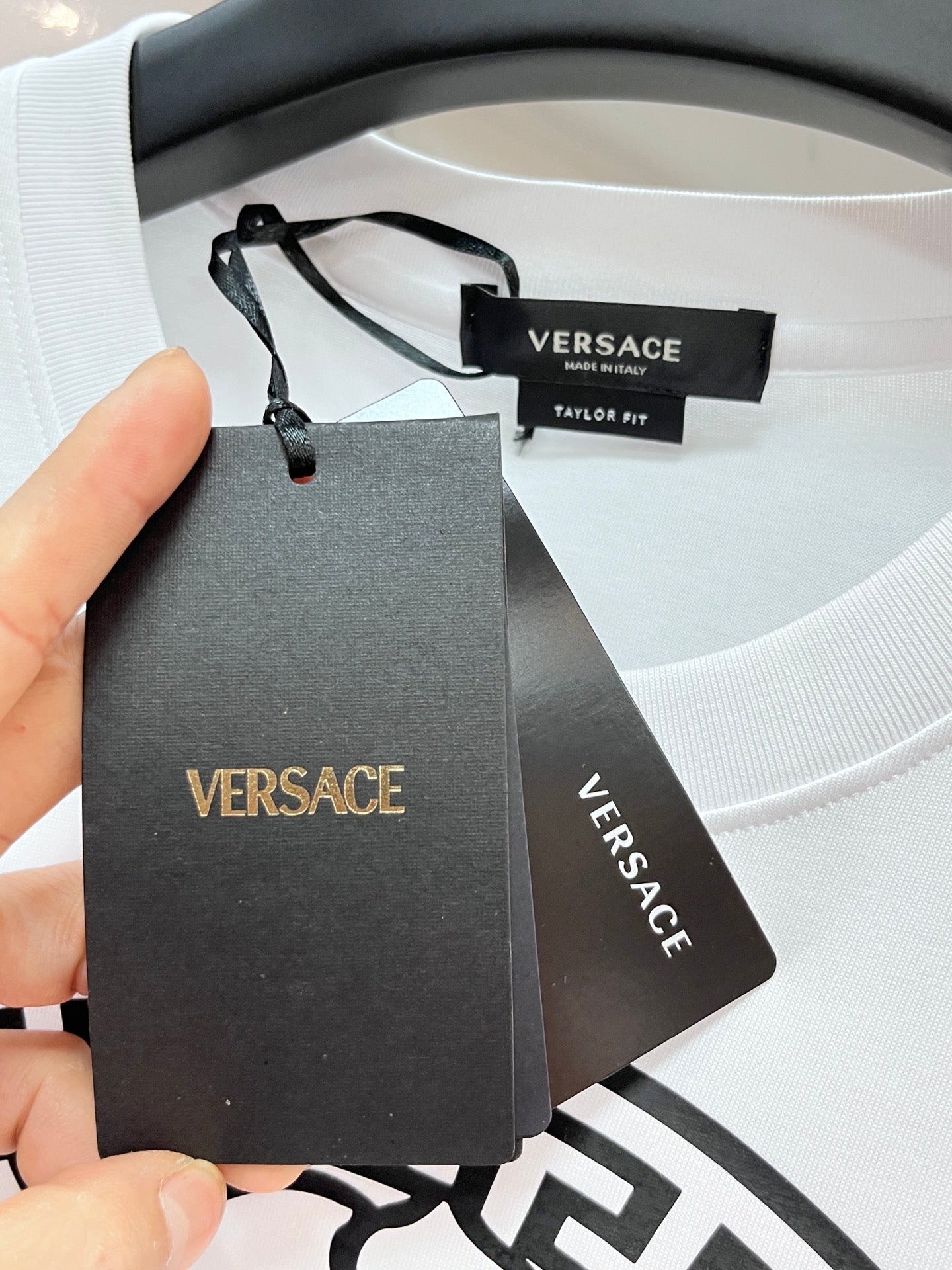 Versace T-shirt price and brand hang tags at neckline