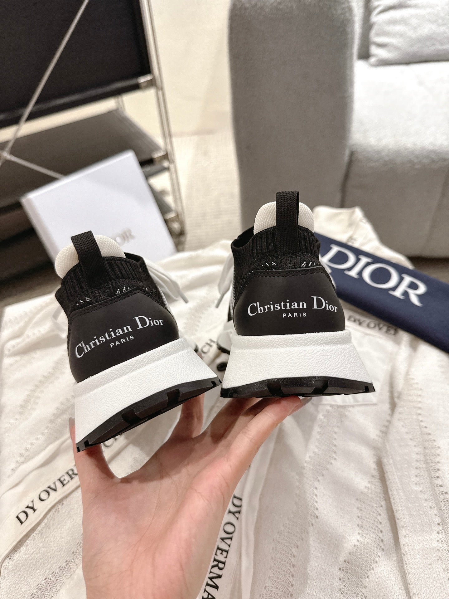 Unisex Dior sneakers back view, black heel with logo patch and white sole