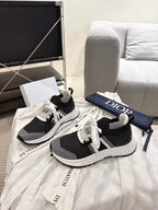 Unisex Dior sneakers, front view with black textured upper and white lace-up