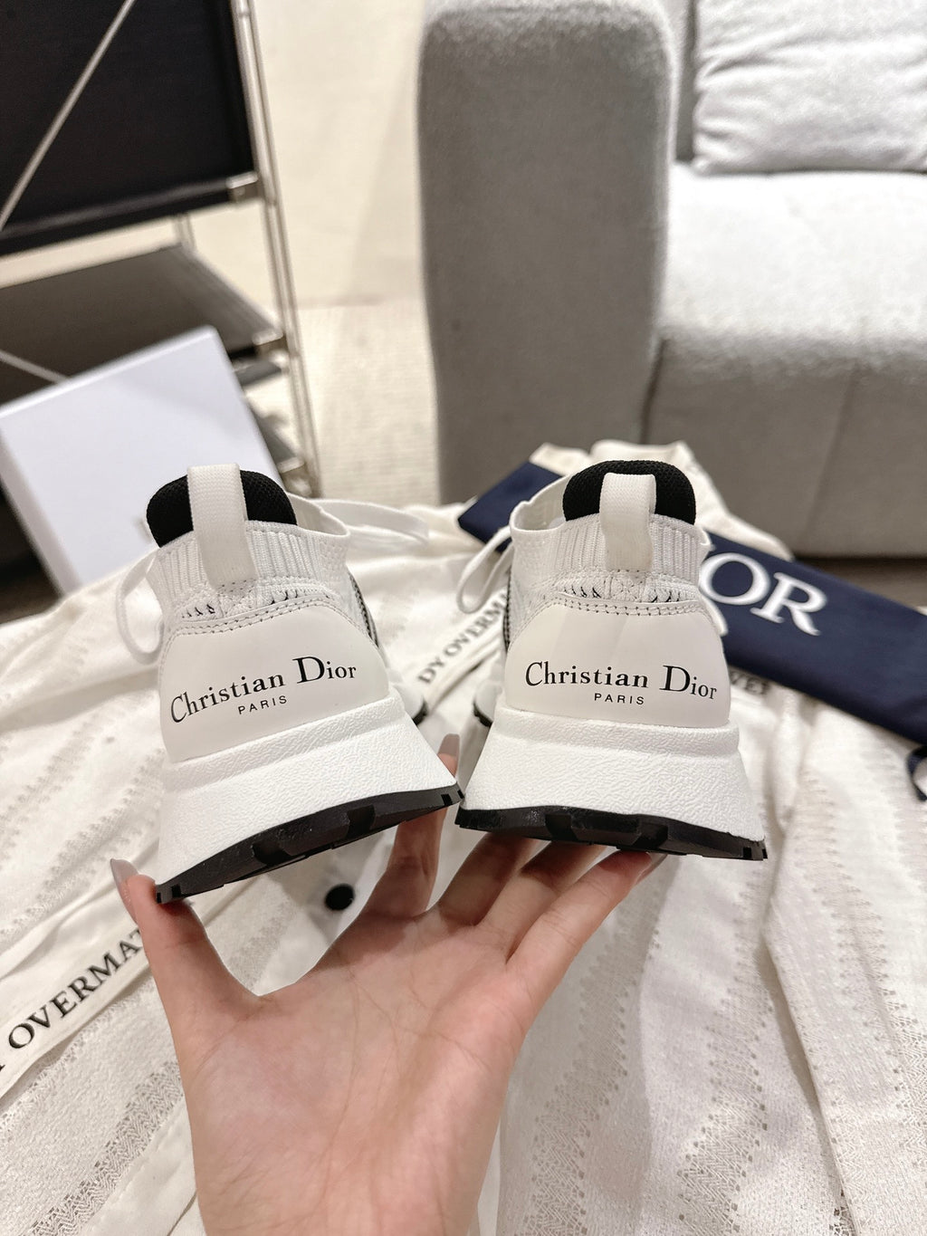 White mesh lace-up sneakers with Dior script on heel and navy pull-tab, pair