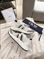 White mesh lace-up sneakers with black side stripes and Dior logo on tongue