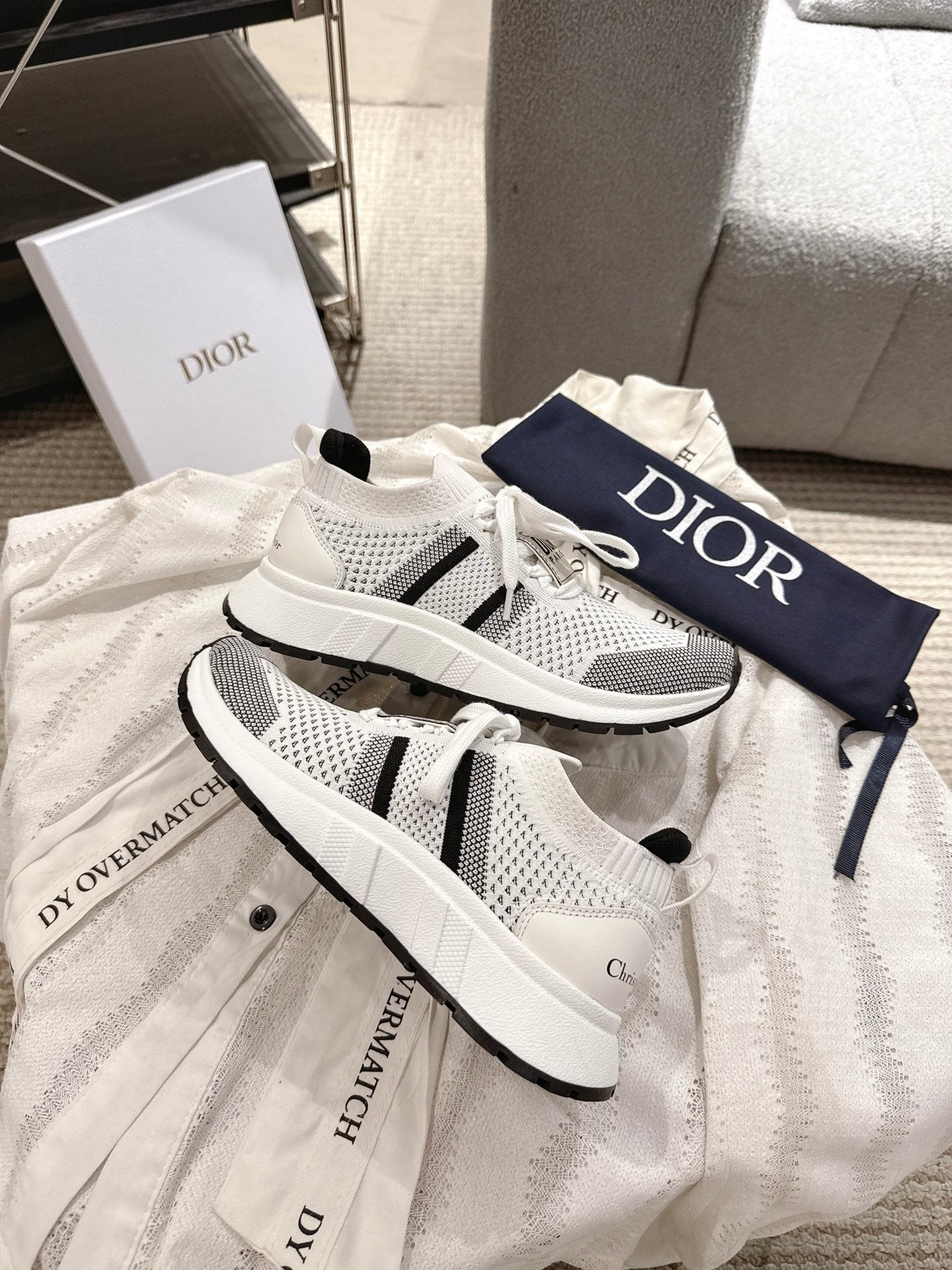 White mesh lace-up sneakers with black side stripes and Dior logo on tongue