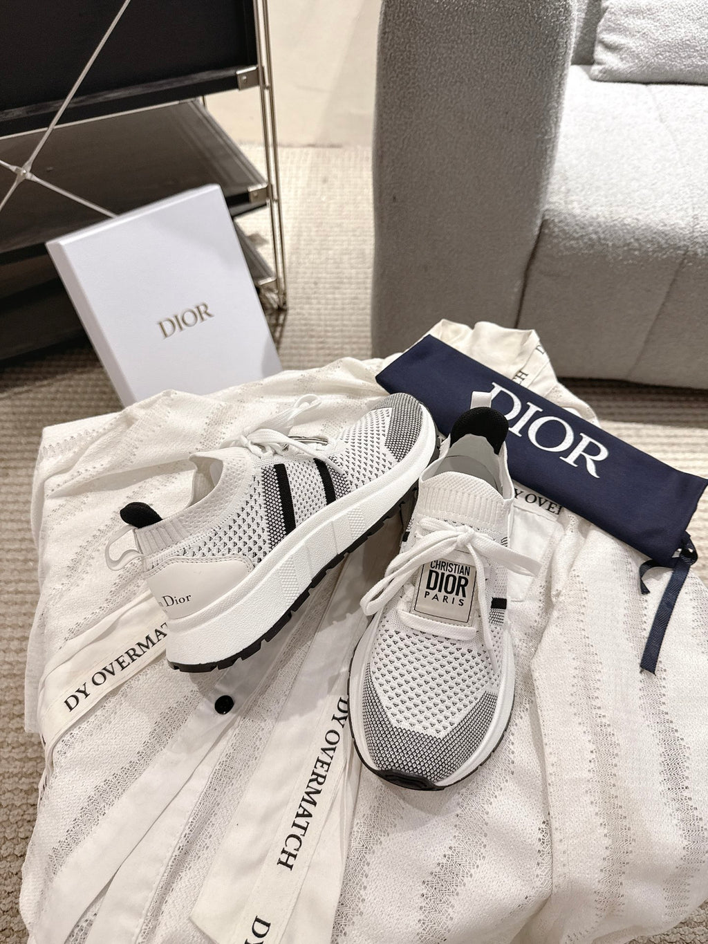 White mesh lace-up sneakers with black side stripes and Dior logo on heel tabs