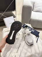 White lace-up sneakers with black outsole tread and Dior-branded heel tab