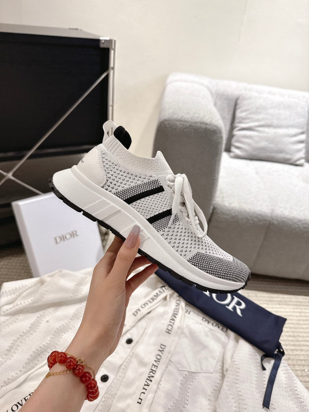White mesh lace-up sneaker with black stripe and Dior logo on navy bag