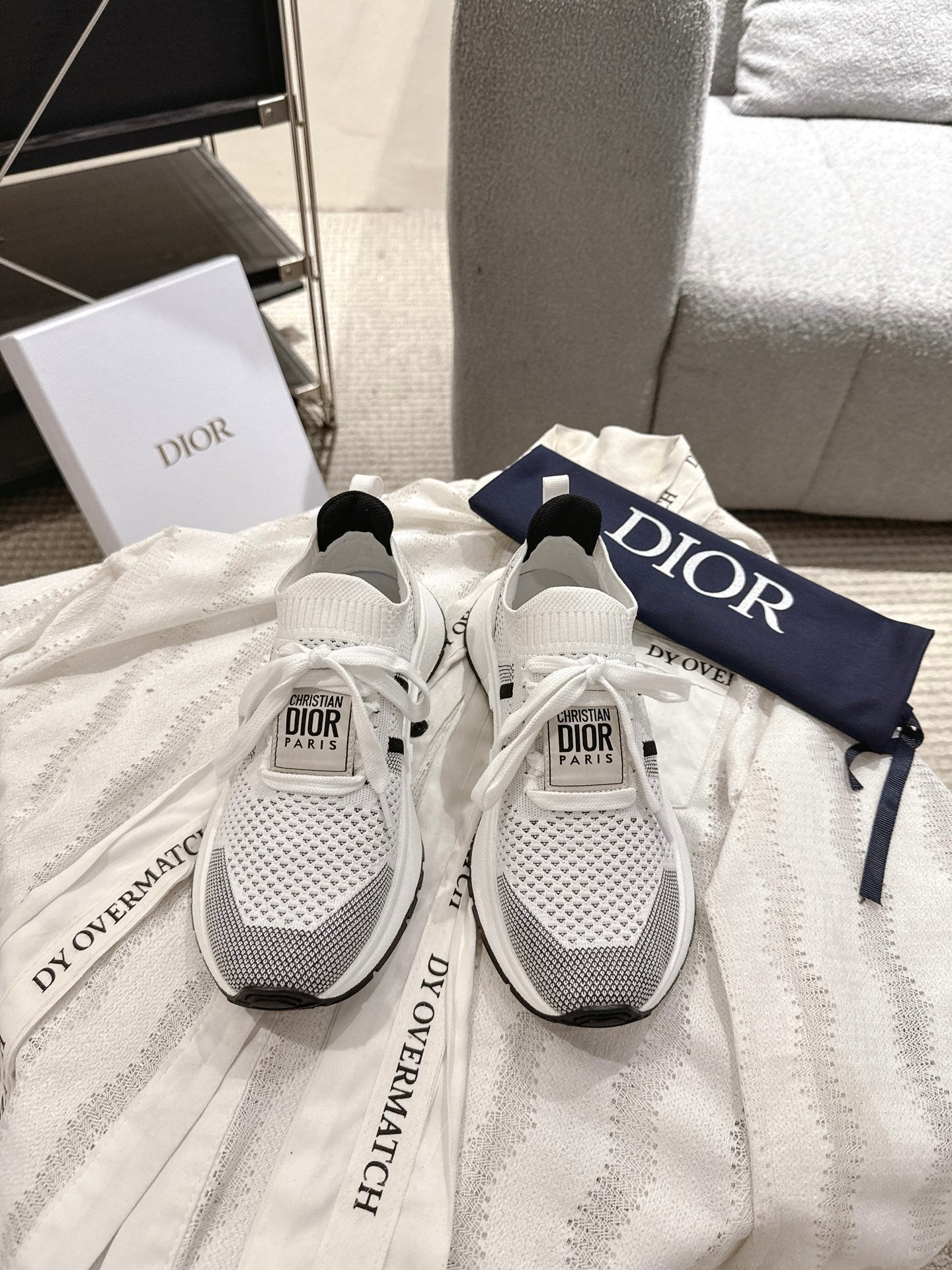 White mesh lace-up sneakers with black accents and Dior logo on tongue, pair