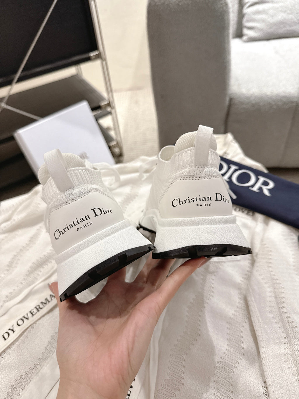Dior unisex white sneakers, close-up of heel branding and black sole edge