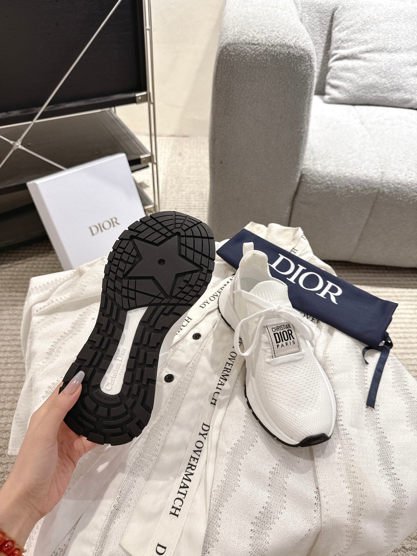 Dior unisex sneakers with black tread outsole and white upper, side-by-side view