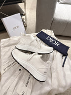 Dior unisex white sneakers with chunky black outsole, lace-up and side profile view
