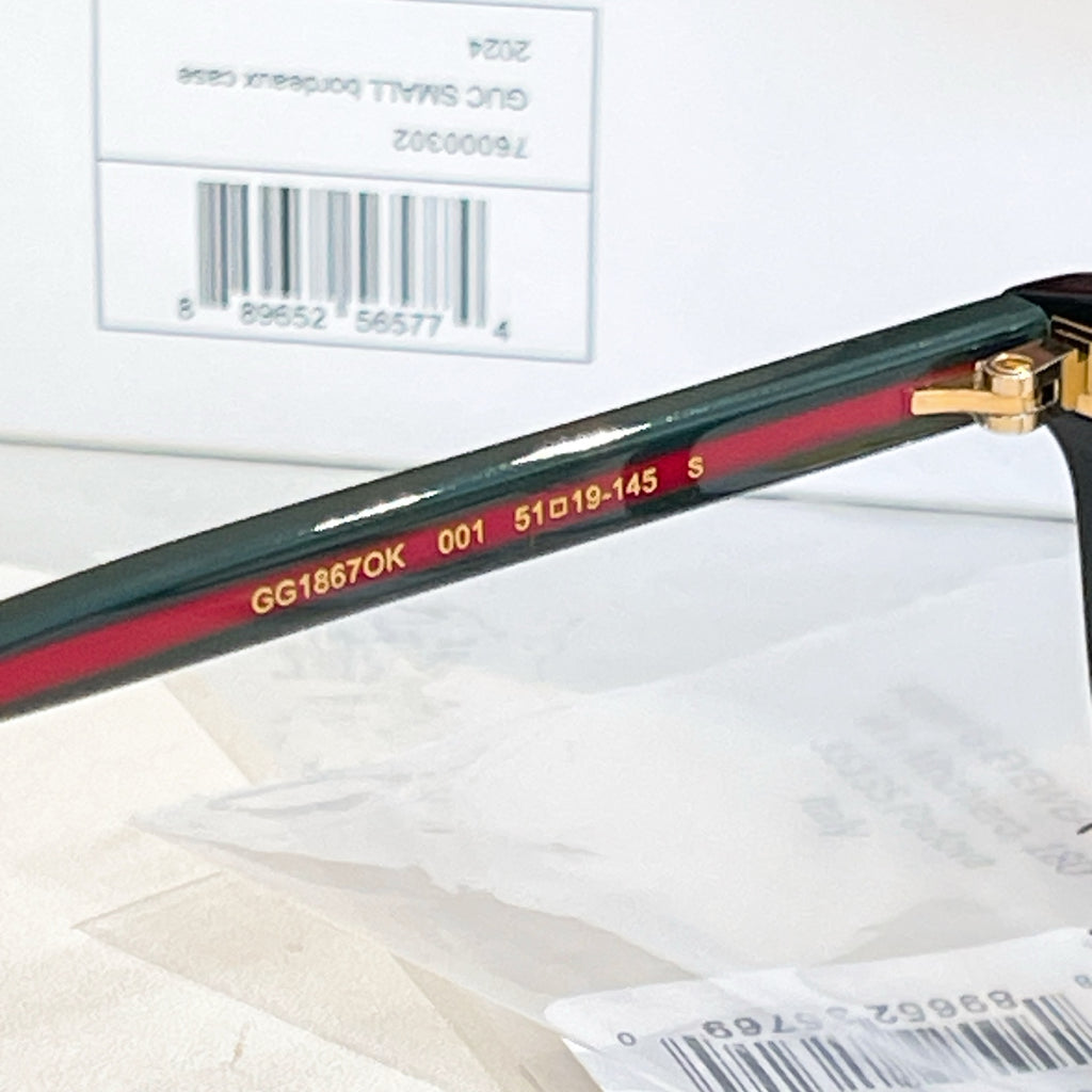 Gucci eyeglass temple arm with green-and-red stripe and engraved model numbers.