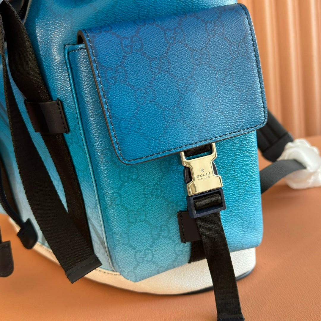 Blue Gucci backpack with front flap, stitched pocket edge, and black crossbody strap.