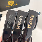 Close-up of black eyeglass frames showing VERSACE text on temple arms