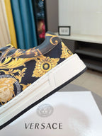 Versace sneakers angled view, dark upper with gold floral print and white midsole