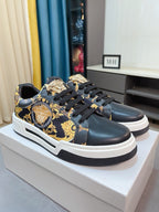 Versace sneakers on display, dark upper with ornate gold print and white sole