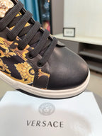 Versace sneakers close-up, dark leather toe and laces with gold baroque details