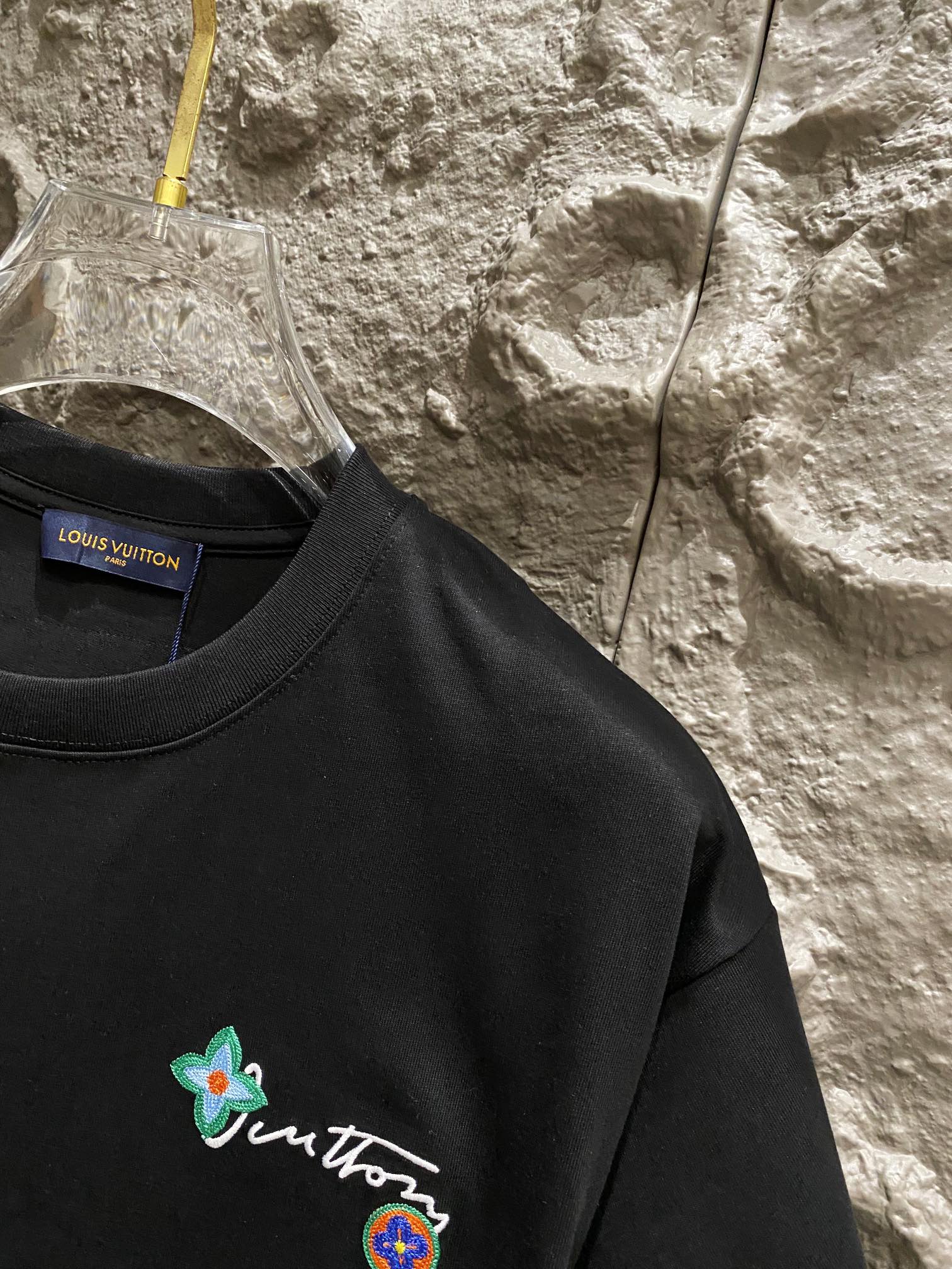 Black T-shirt chest with small flower and crest embroidery