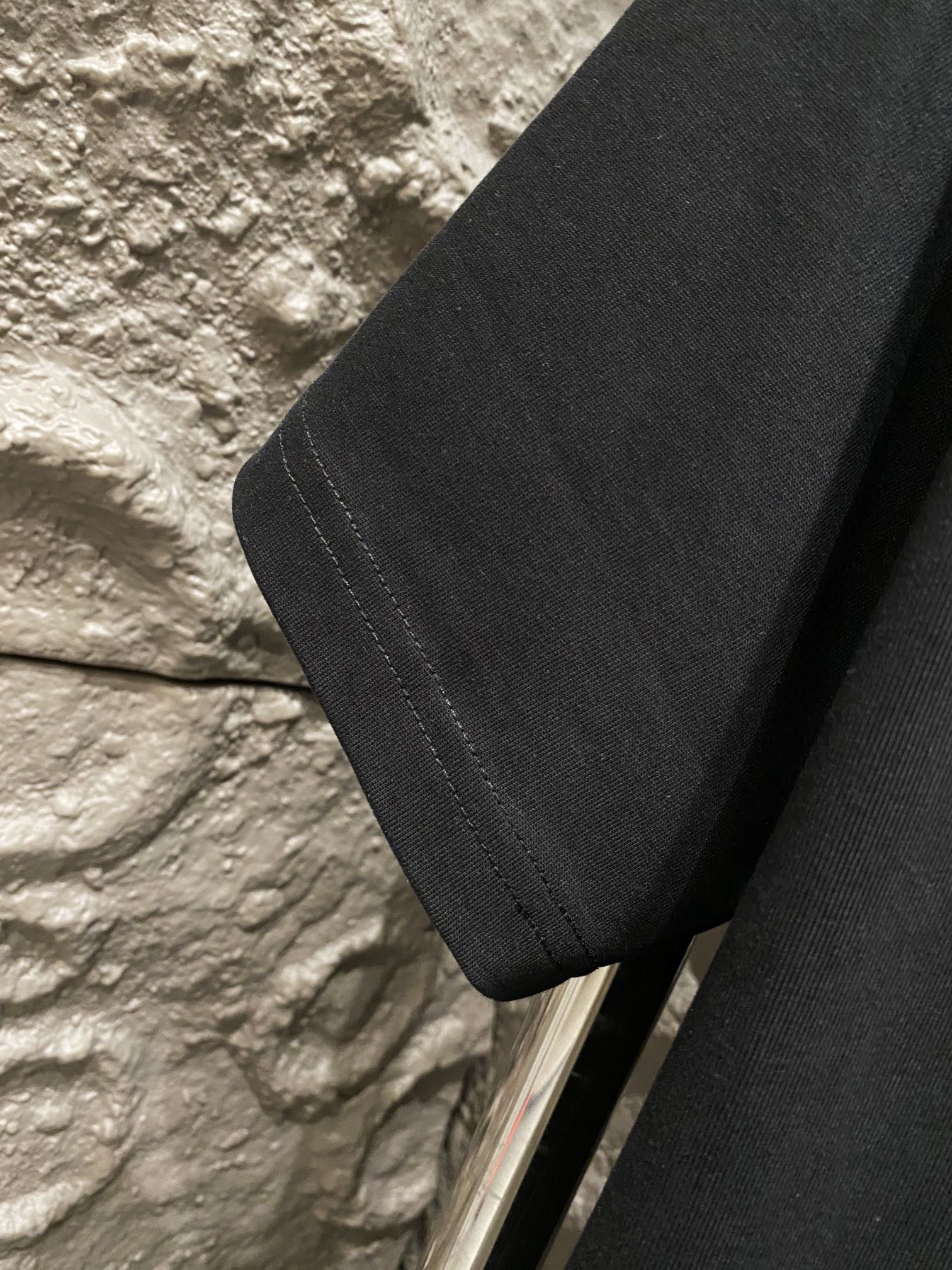 Black T-shirt with visible side seam and short sleeve hem