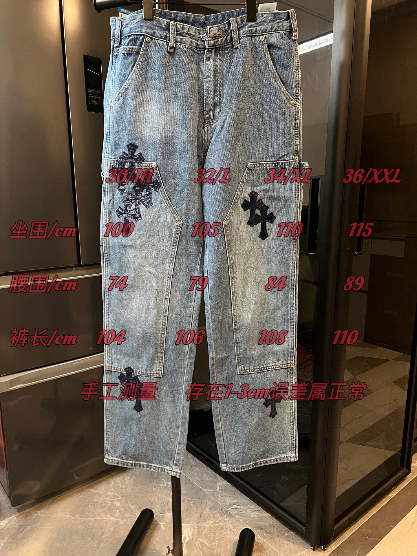 Light-wash denim pants with black cross applique on both legs