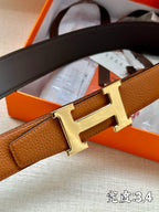 Leather belt with brown strap and silver-tone H buckle detail, angled view.