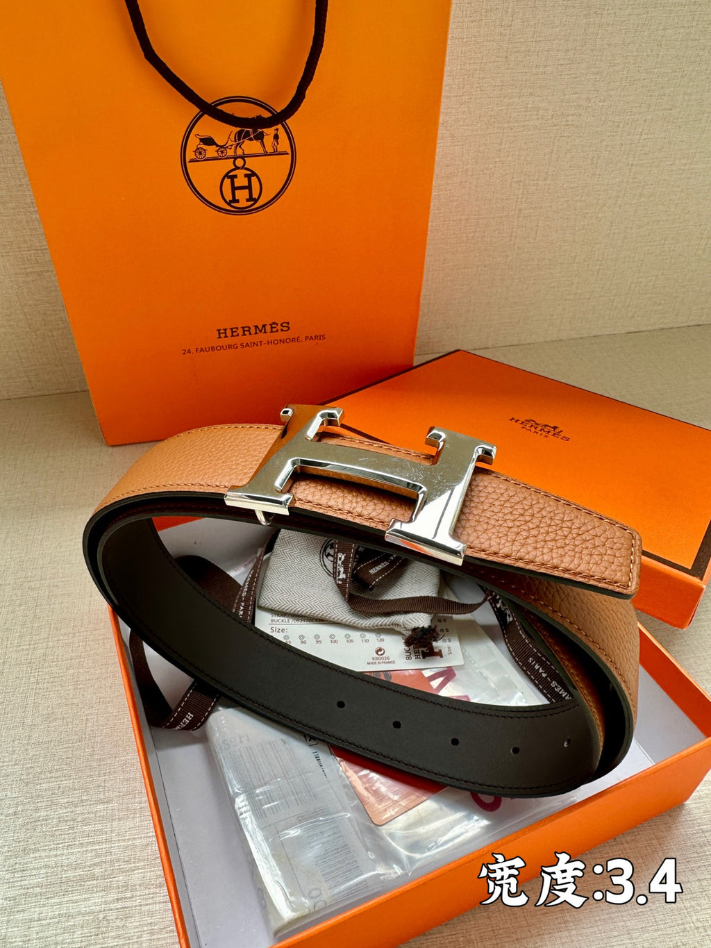 Leather belt with brown and dark straps and silver-tone H buckle, with papers in box.