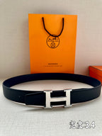Dark blue leather belt with silver H-style buckle, flat strap end visible