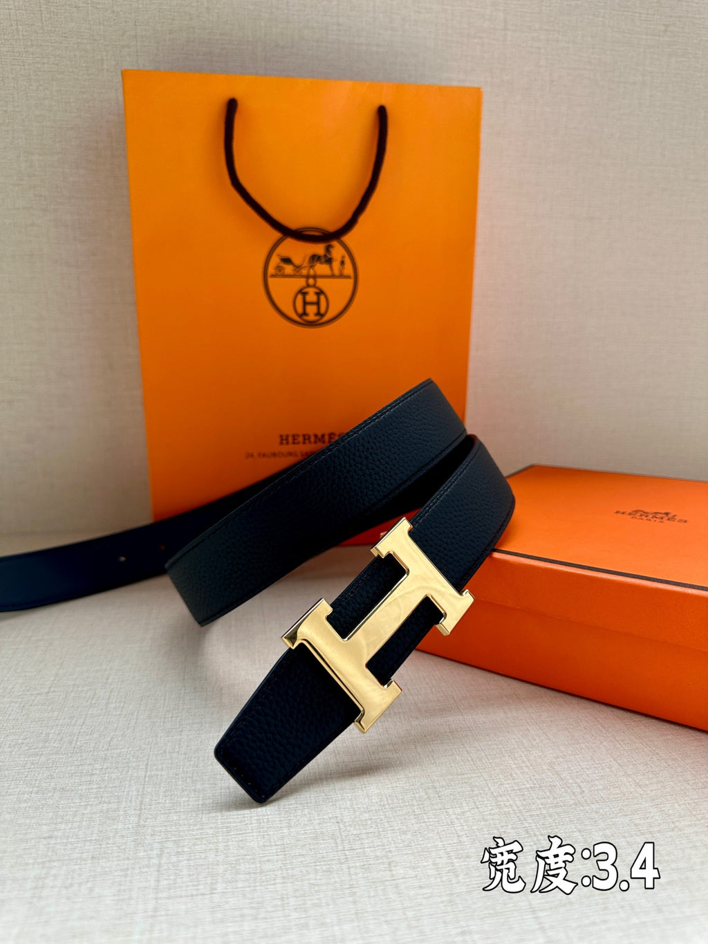 Dark blue leather belt with silver buckle on top of stacked box items