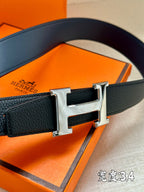 Dark blue leather belt close-up with silver buckle and textured strap panel