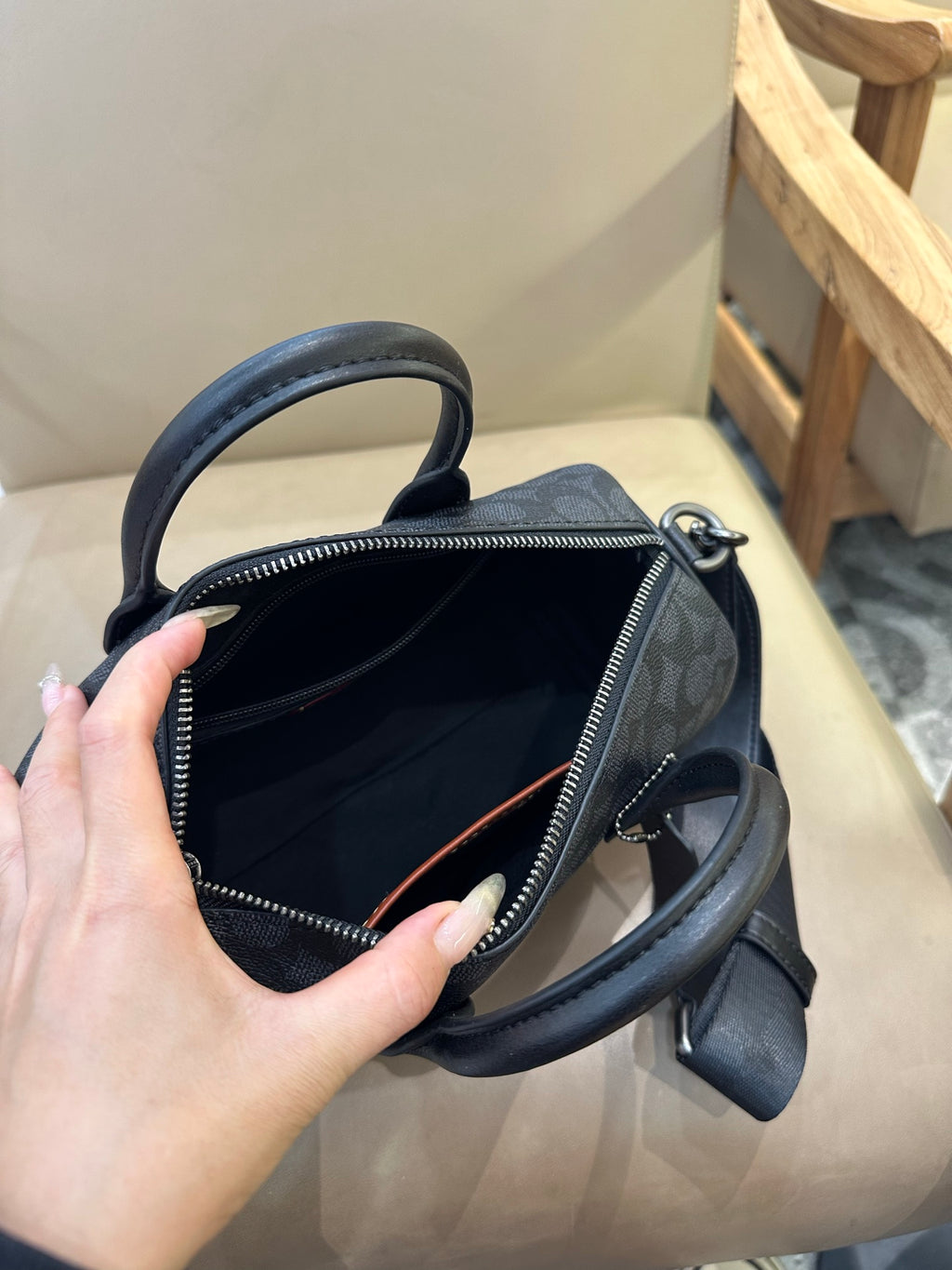 Coah bag interior view with zip opening and crossbody strap, dark patterned exterior