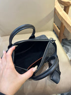 Coah bag interior view with zip opening and crossbody strap, dark patterned exterior