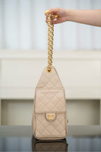 Quilted light beige mini shoulder bag with chain strap and CC logo on front.