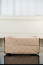 Quilted light beige clutch-style bag with flap and stitched diamond pattern.