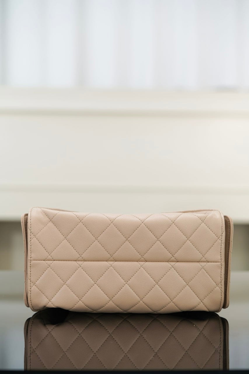 Quilted light beige clutch-style bag with flap and stitched diamond pattern.