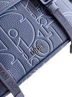 Dior blue textured leather bag close-up with embossed monogram pattern and Dior lettering