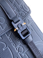 Dior blue bag close-up of clasp and strap with embossed monogram leather texture