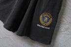 Balenciaga dark shorts with blue crest logo patch on the hem
