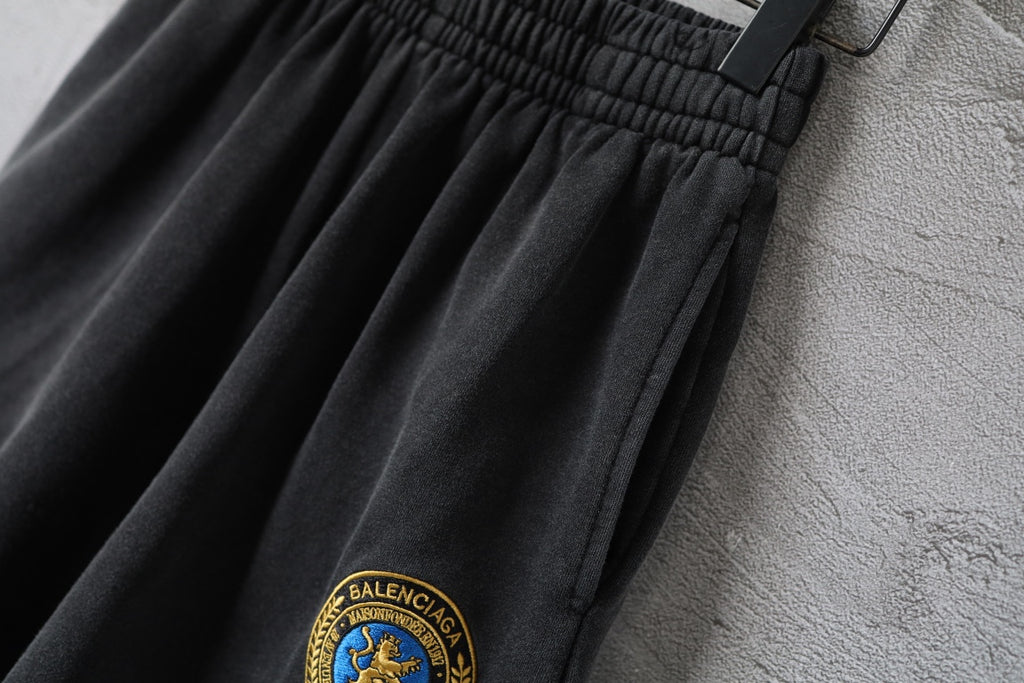 Balenciaga dark shorts fabric with small crest logo at the hem