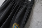 Balenciaga dark shorts fabric with small crest logo at the hem