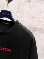 Black short-sleeve T-shirt on hanger with partial red Louis Vuitton logo