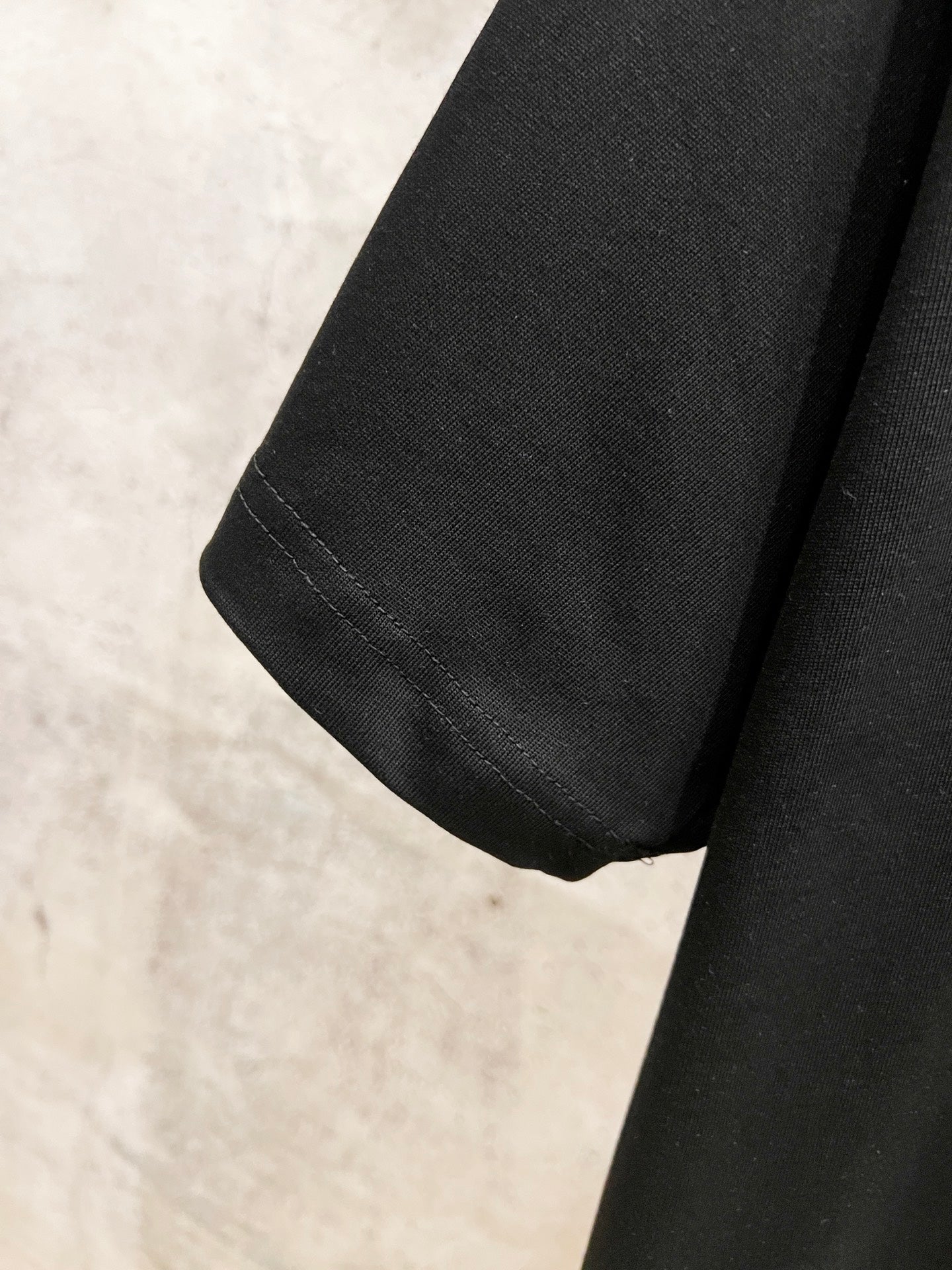 Black short-sleeve T-shirt with stitched hem and sleeve cuff seam detail