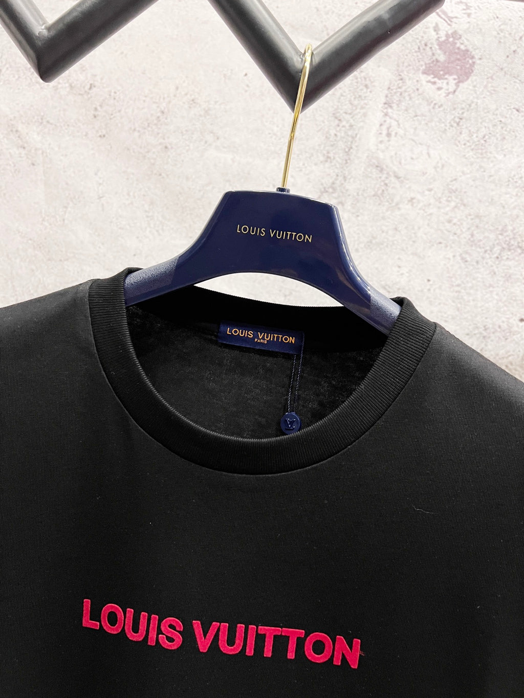 Black short-sleeve T-shirt with red Louis Vuitton logo and blue neckline tag