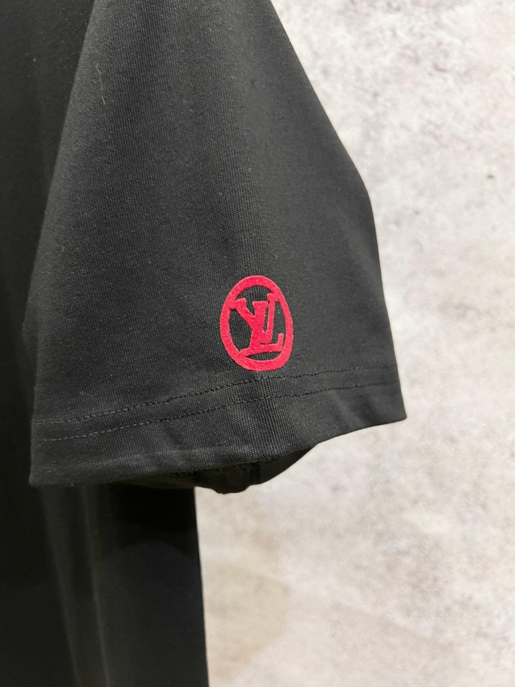 Black short-sleeve T-shirt with red circular LV emblem on the sleeve